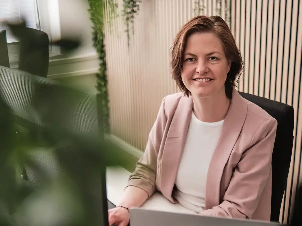 Christine Glade arbeitet am Laptop in einem Büro und symbolisiert die strukturierte digitale Buchhaltung, die wir für Unternehmen anbieten.